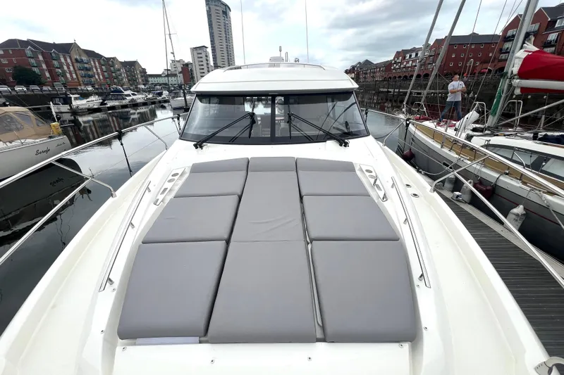 Serenity Yacht Photos Pics 2023 Prestige 460S yacht with sunbathing cushions docked in a marina.