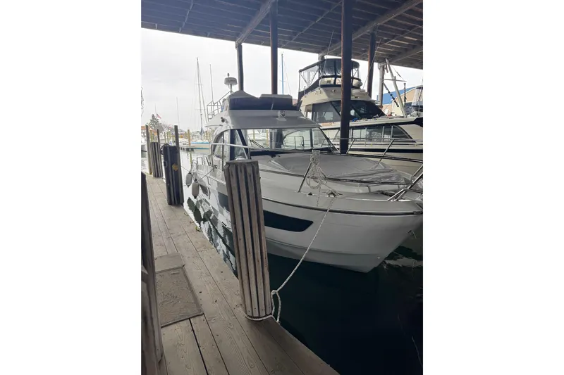  Yacht Photos Pics 2025 Beneteau Antares 11 Fly yacht docked in a marina under a covered area.