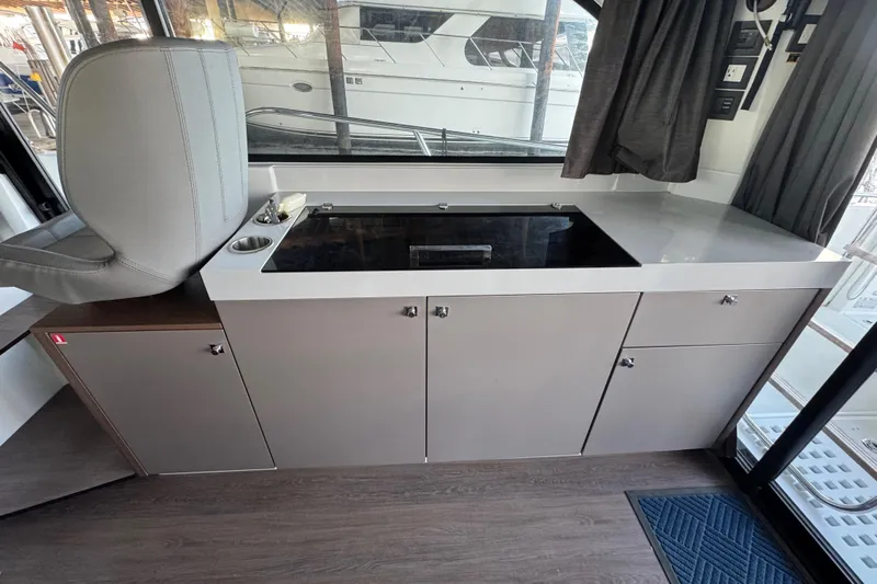  Yacht Photos Pics Interior of 2025 Beneteau Antares 11 Fly, featuring modern kitchen cabinetry and seating.