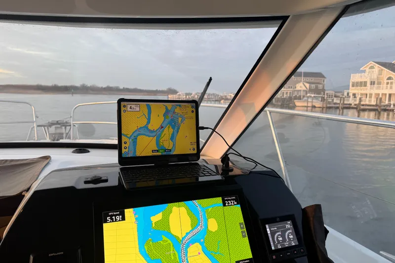  Yacht Photos Pics Interior view of 2025 Beneteau Antares 11 Fly with navigation screens displaying maps.