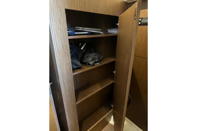  Yacht Photos Pics Wooden storage cabinet with shelves inside a 2025 Beneteau Antares 11 Fly boat.