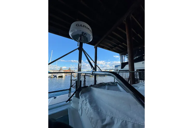  Yacht Photos Pics 2025 Beneteau Antares 11 Fly with Garmin radar, docked under a wooden canopy.