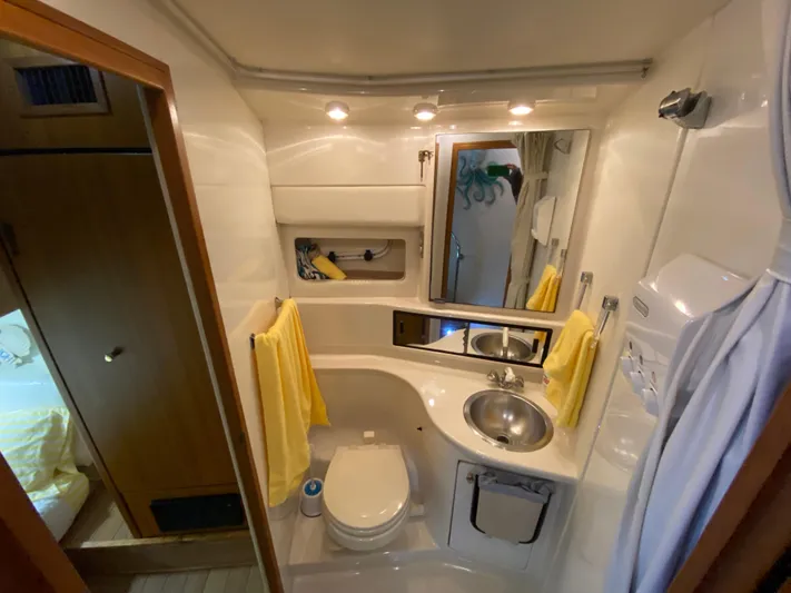  Yacht Photos Pics 2001 Bayliner 3988 yacht bathroom with sink, toilet, mirror, and yellow towels.