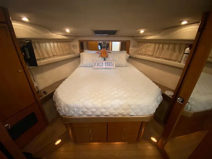  Yacht Photos Pics Cozy bedroom interior of 2001 Bayliner 3988 yacht with plush bedding and ambient lighting.