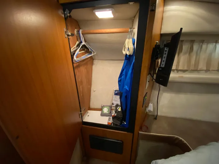  Yacht Photos Pics Closet interior of 2001 Bayliner 3988 yacht with hangers and clothing.