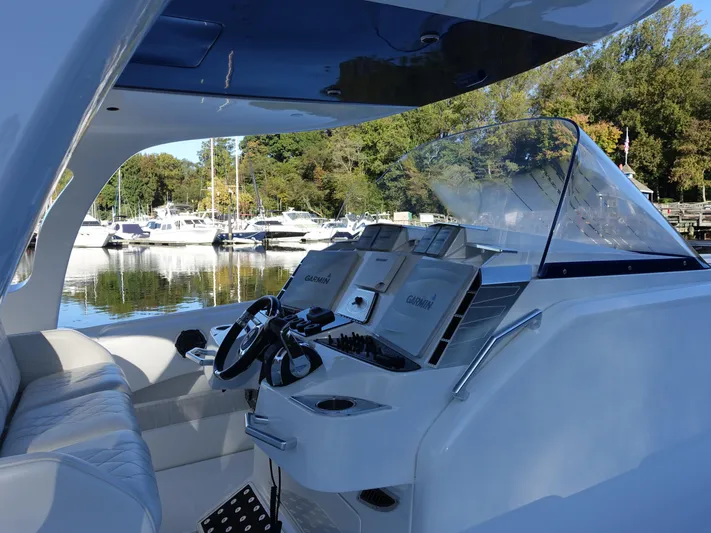  Yacht Photos Pics 2014 Cigarette 42 Huntress boat interior with modern controls and scenic marina view.