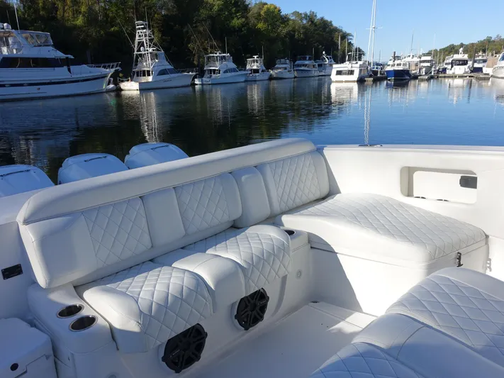  Yacht Photos Pics 2014 Cigarette 42 Huntress boat with luxurious white seating in a marina.