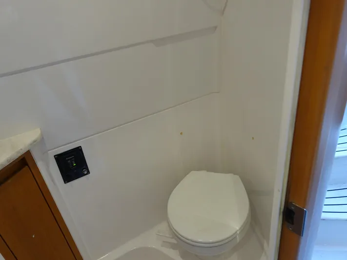  Yacht Photos Pics 2014 Cigarette 42 Huntress boat bathroom with white toilet and wooden cabinet.