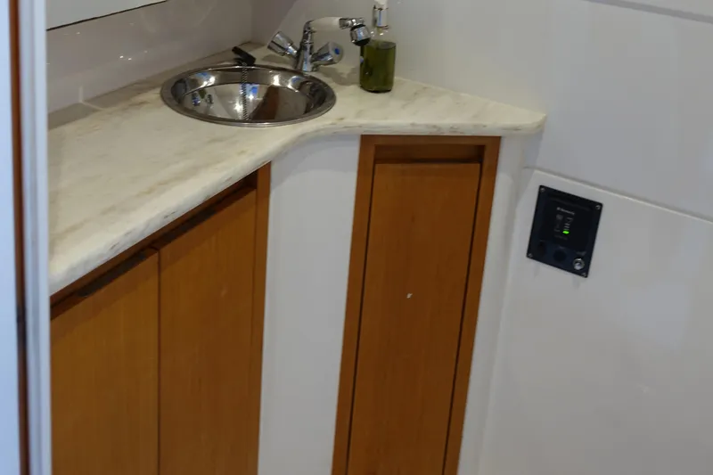  Yacht Photos Pics 2014 Cigarette 42 Huntress bathroom sink with wooden cabinets and marble countertop.