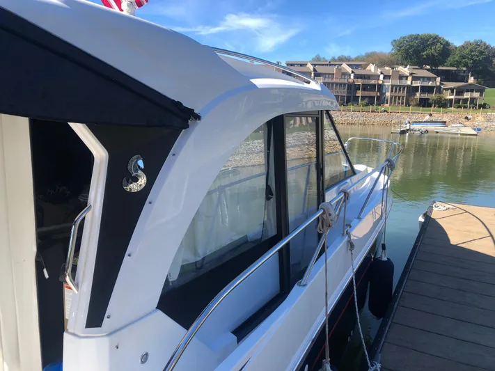  Yacht Photos Pics 2022 Beneteau Antares 9 docked by waterfront homes, sunny day.