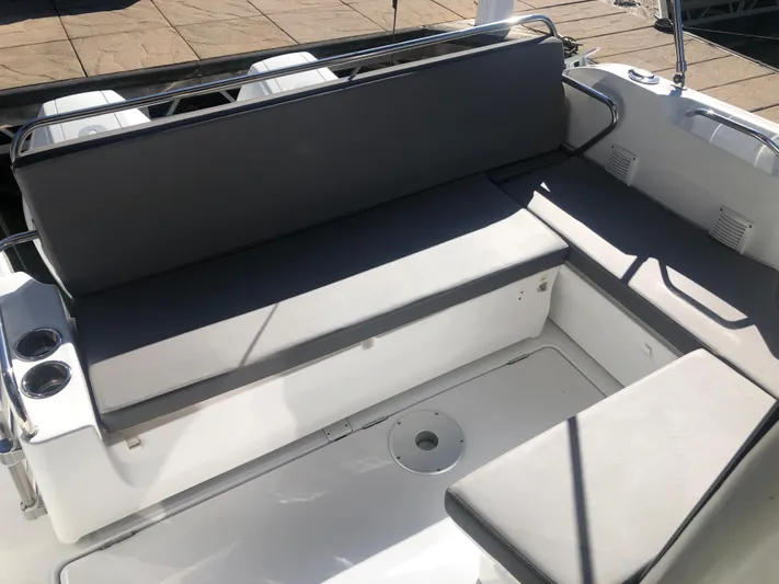  Yacht Photos Pics 2022 Beneteau Antares 9 boat seating area with gray cushions and cup holders.