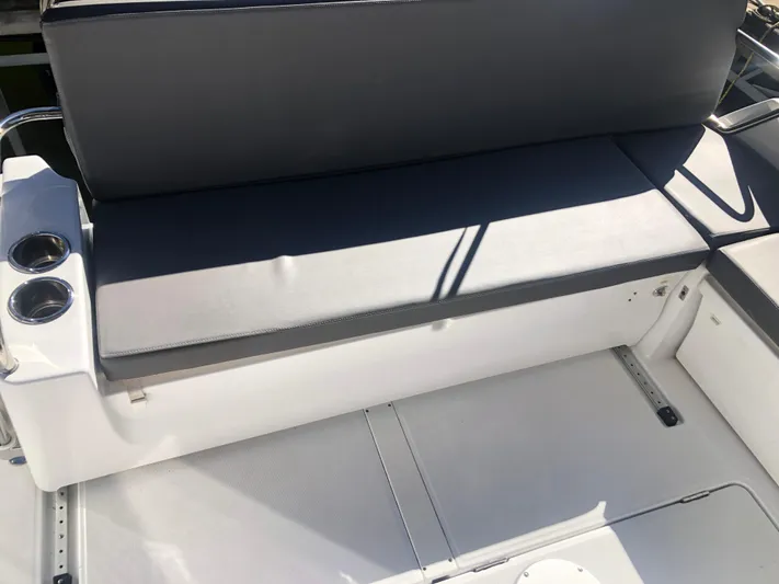  Yacht Photos Pics Beneteau Antares 9 2022 boat seating area with cup holders and cushioned bench.