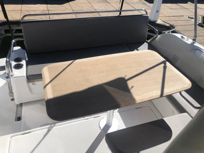  Yacht Photos Pics Beneteau Antares 9 (2022) cockpit with wooden table and cushioned seating.