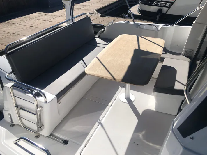  Yacht Photos Pics 2022 Beneteau Antares 9 boat deck with seating and table in sunlight.