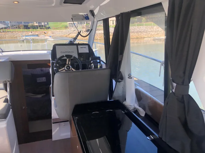  Yacht Photos Pics Interior of 2022 Beneteau Antares 9 boat with steering wheel and navigation equipment.