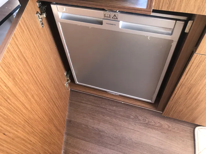  Yacht Photos Pics Compact Dometic fridge in 2022 Beneteau Antares 9 boat interior, wooden cabinetry.