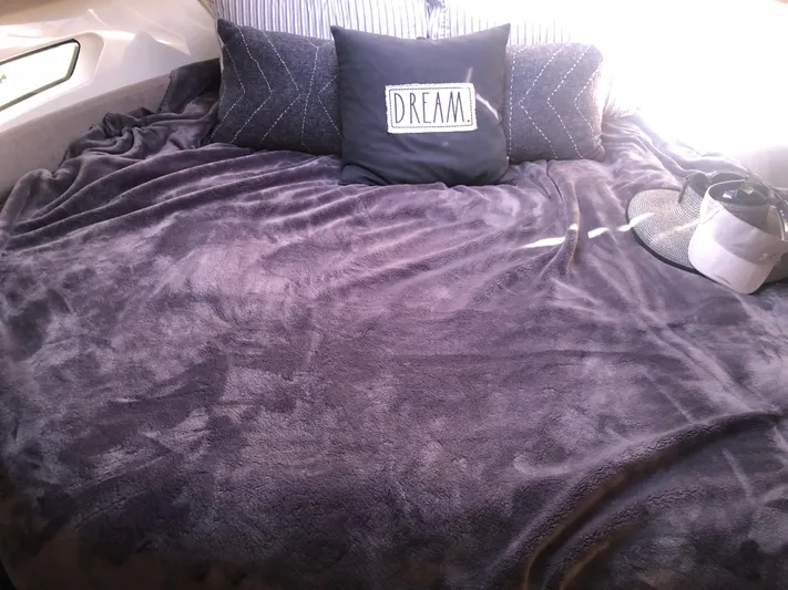  Yacht Photos Pics Cozy bed in 2022 Beneteau Antares 9 cabin with plush pillows and blanket.