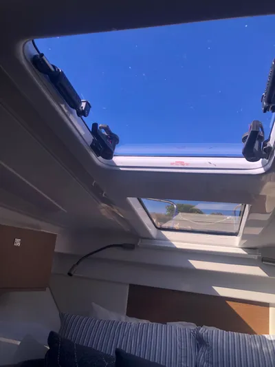  Yacht Photos Pics Interior view of 2022 Beneteau Antares 9 with open skylight and blue sky.