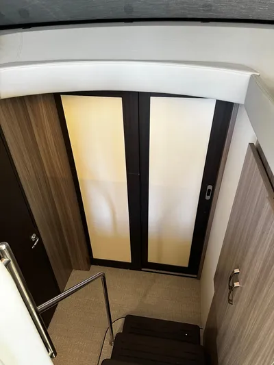 Fully Vested Yacht Photos Pics Interior view of 2022 Regal 42 FXO yacht, featuring modern wood paneling and sliding doors.