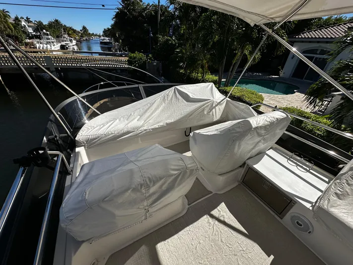 Fully Vested Yacht Photos Pics 2022 Regal 42 FXO yacht with covered seating on a sunny waterfront.