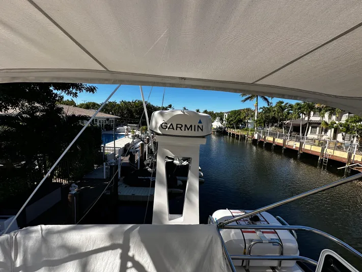 Fully Vested Yacht Photos Pics 2022 Regal 42 FXO yacht with Garmin equipment, docked in a scenic canal setting.