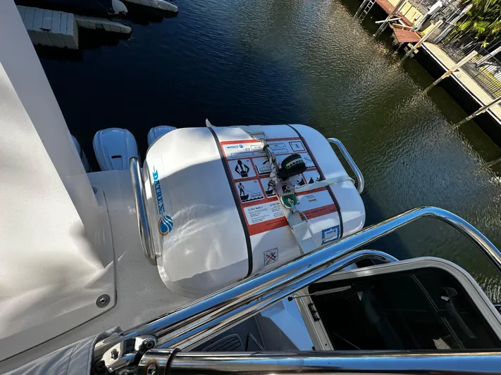 Fully Vested Yacht Photos Pics 2022 Regal 42 FXO yacht with safety equipment on deck, docked by the water.