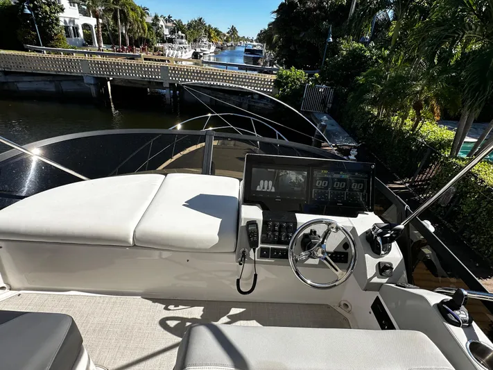 Fully Vested Yacht Photos Pics Cockpit view of 2022 Regal 42 FXO yacht with modern controls and scenic canal backdrop.
