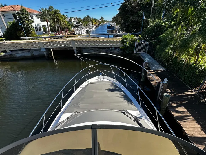 Fully Vested Yacht Photos Pics 2022 Regal 42 FXO yacht navigating a scenic canal with lush greenery.