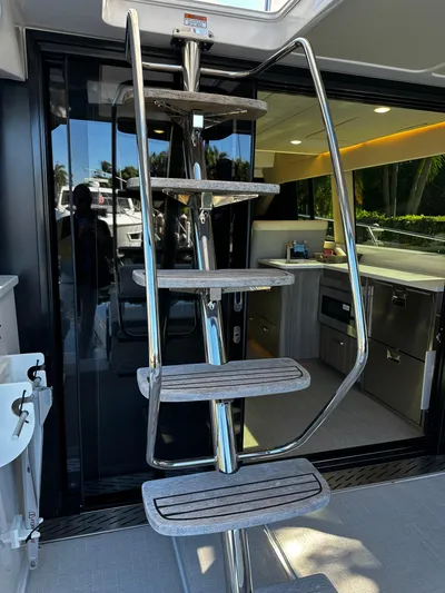 Fully Vested Yacht Photos Pics Stainless steel staircase on 2022 Regal 42 FXO yacht, leading to modern interior kitchen.