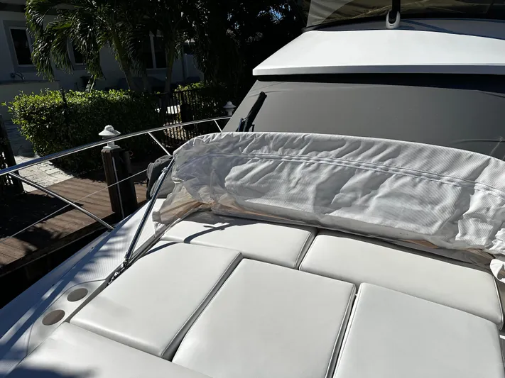 Fully Vested Yacht Photos Pics 2022 Regal 42 FXO yacht with sunpad, docked in a lush, tropical setting.