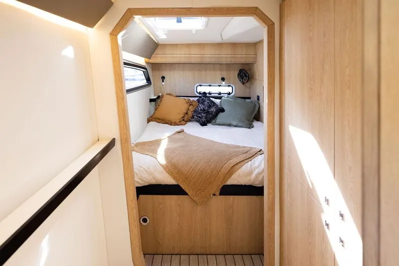  Yacht Photos Pics Modern cabin interior of Introductory Cure Marine 55 yacht, 2025 model, with cozy bedding.