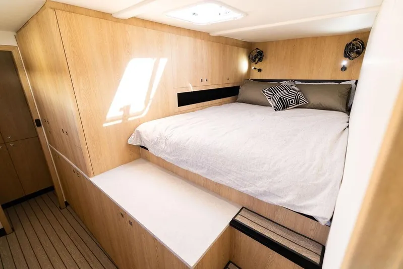  Yacht Photos Pics Luxurious cabin interior of 2025 Introductory Cure Marine 55 yacht, featuring a cozy bed.