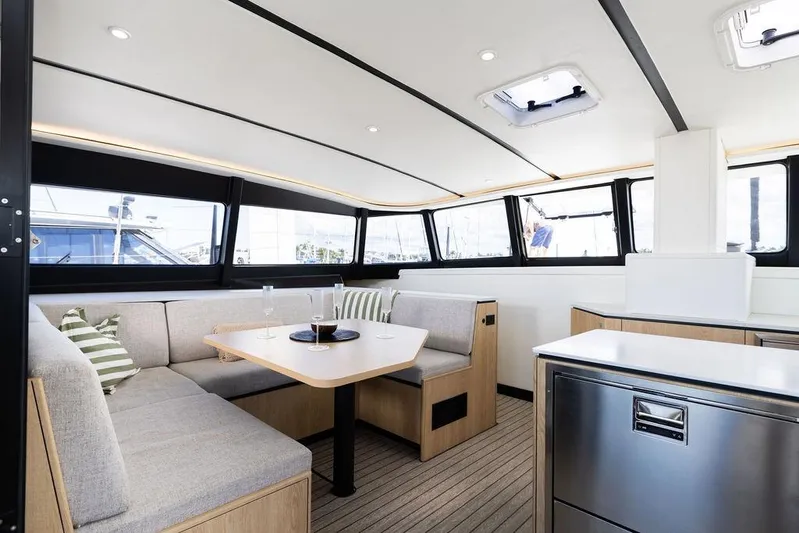  Yacht Photos Pics Luxurious interior of 2025 Introductory Cure Marine 55 yacht with modern seating and dining area.