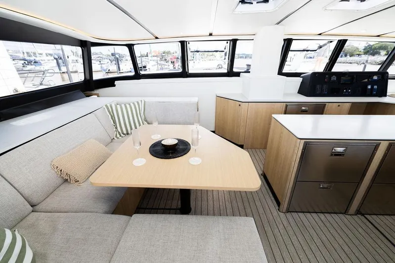  Yacht Photos Pics Luxurious interior of 2025 Introductory Cure Marine 55 yacht with modern seating and dining area.