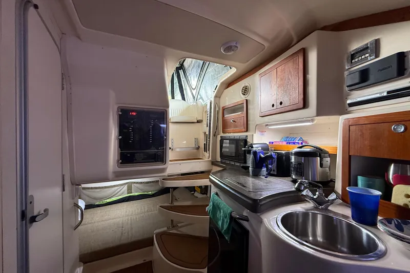  Yacht Photos Pics 2007 Grady-White Express 305 boat interior with kitchenette, sink, and wooden cabinets.