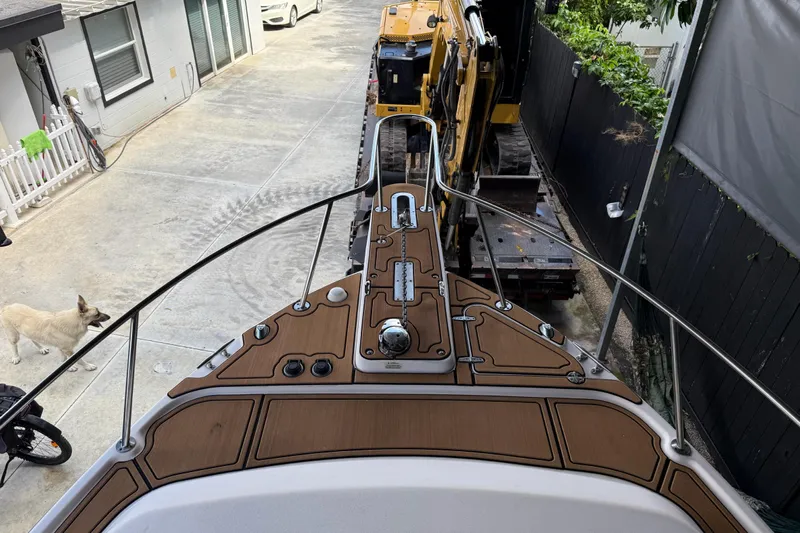  Yacht Photos Pics 2007 Grady-White Express 305 boat docked near construction equipment and a dog.