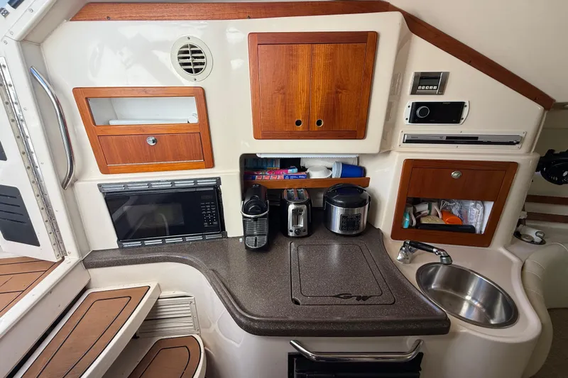  Yacht Photos Pics 2007 Grady-White Express 305 boat kitchen with appliances and wooden cabinets.
