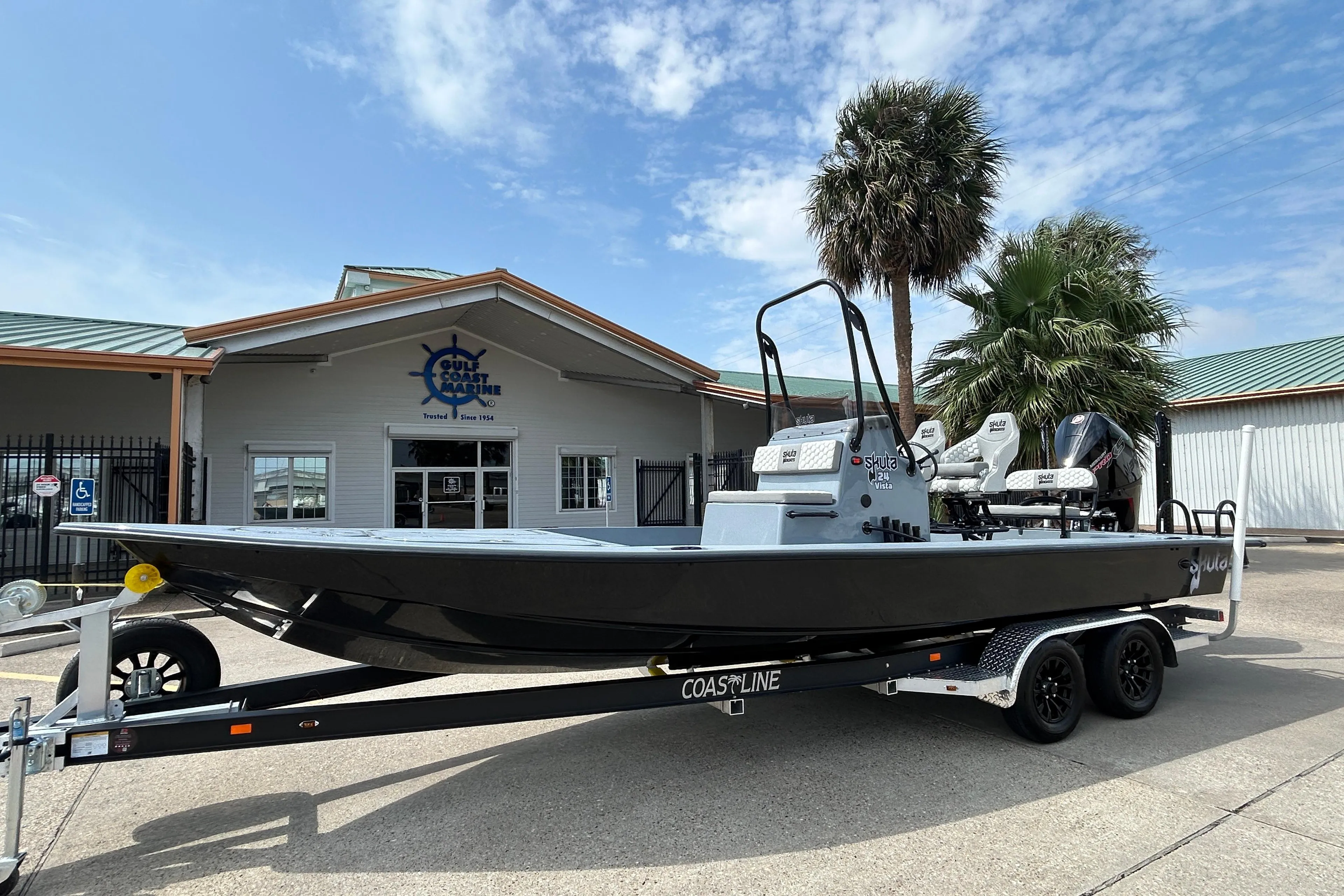 2026 Skuta 24 Vista boat on trailer outside Gulf Coast Marine dealership.