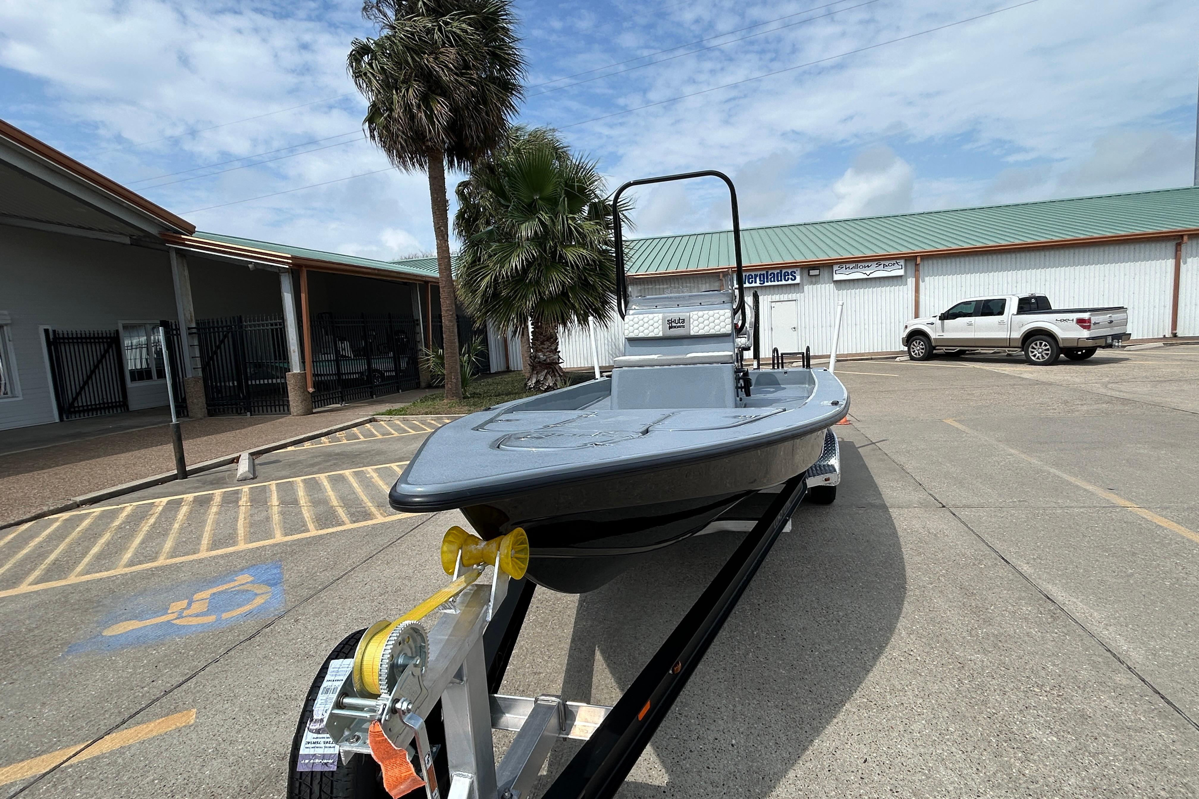 2026 Skuta 24 Vista boat on trailer in parking lot, palm trees in background.