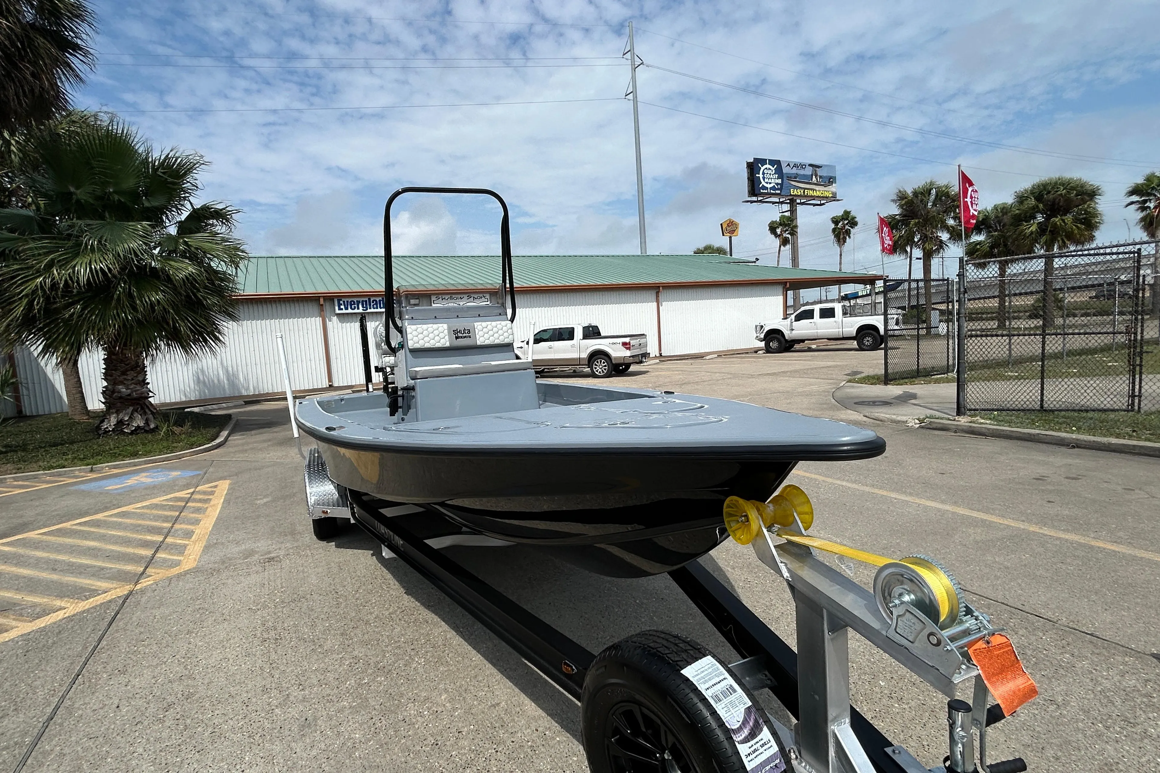 2026 Skuta 24 Vista boat on trailer in parking lot, palm trees in background.