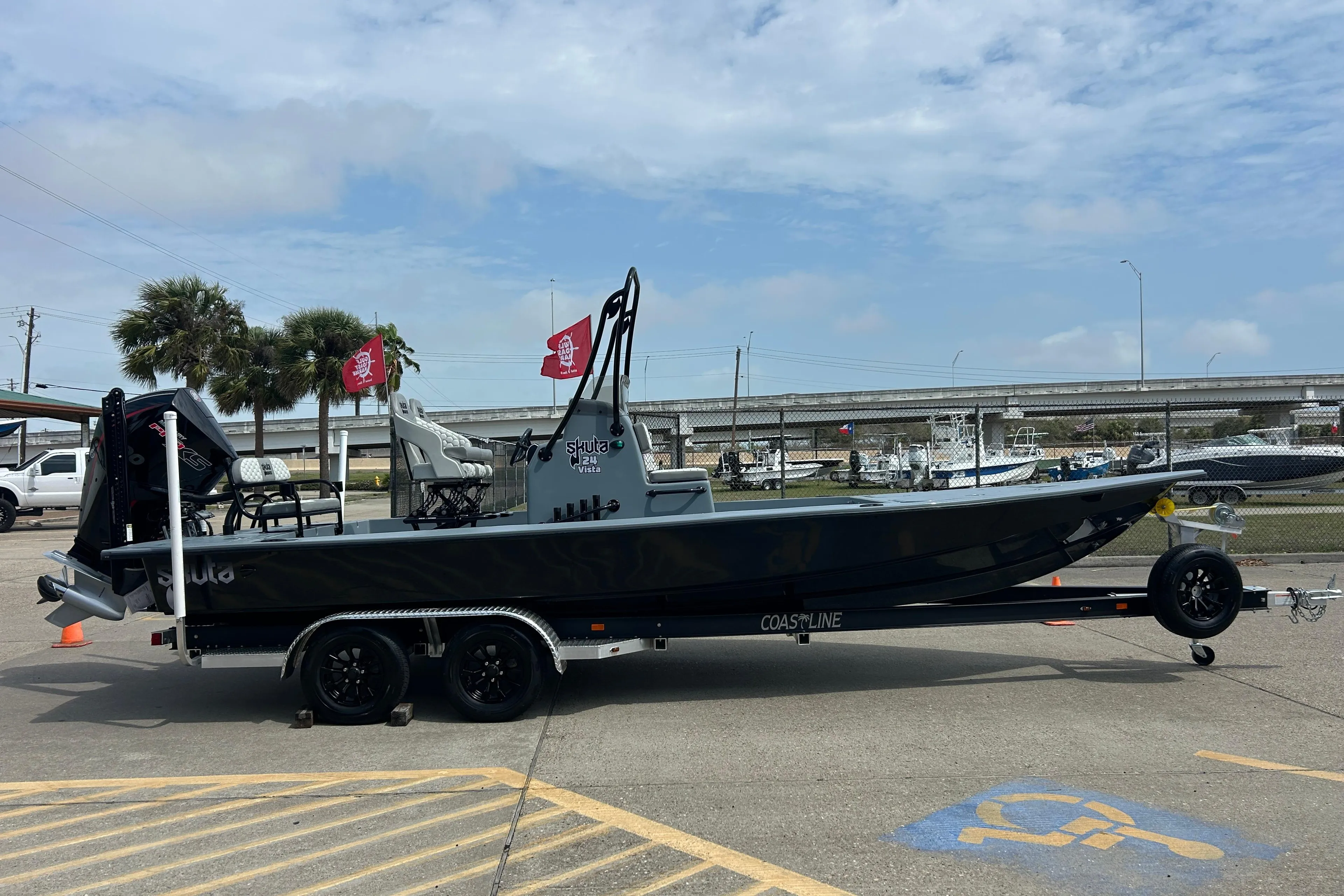2026 Skuta 24 Vista boat on trailer, parked outdoors under cloudy sky.
