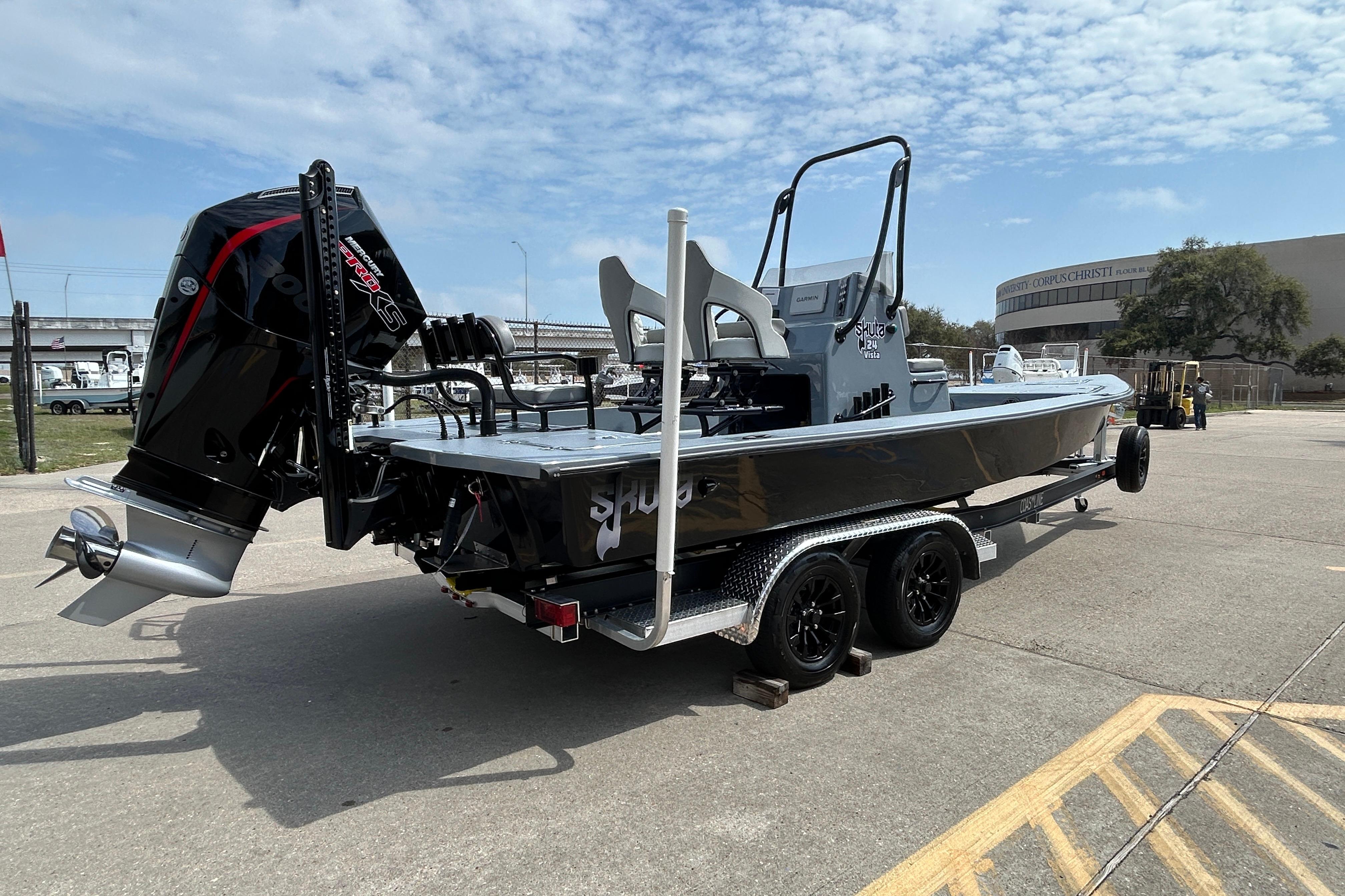 2026 Skuta 24 Vista boat on trailer with powerful outboard motor, parked outdoors.