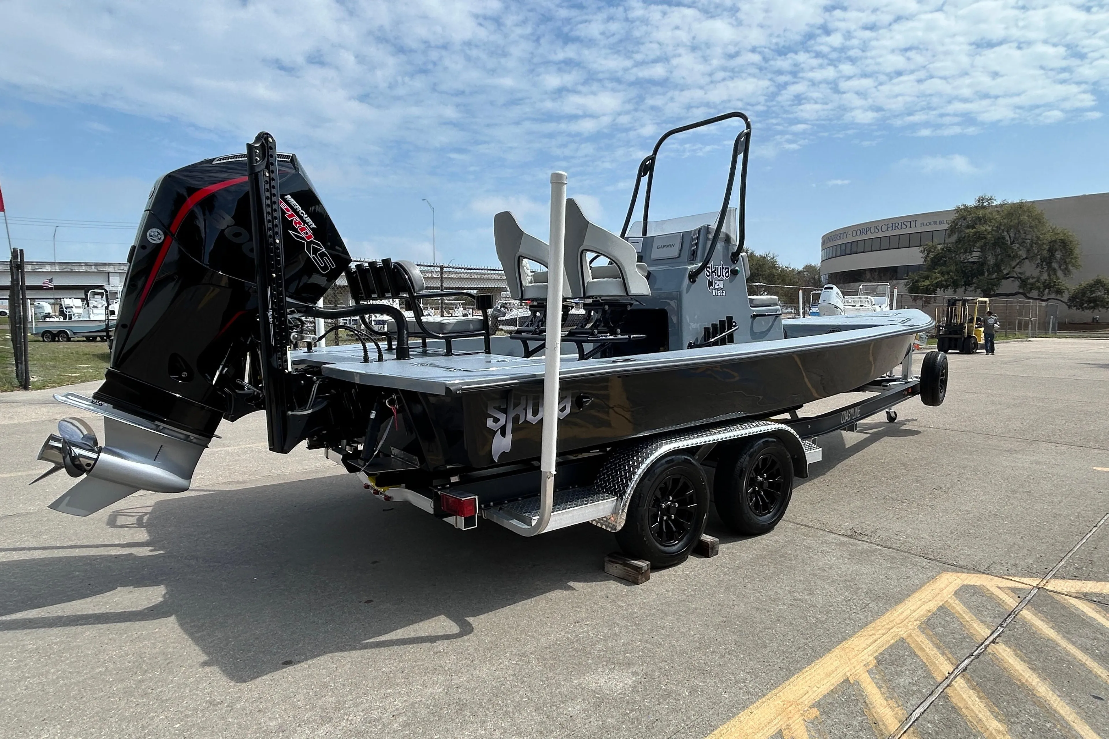 2026 Skuta 24 Vista boat on trailer with powerful outboard motor, parked outdoors.