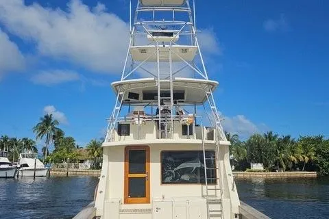 Andiamo Yacht Photos Pics 1991 Donzi 65 Sportfisher yacht docked, featuring a tall tower and clear blue sky.