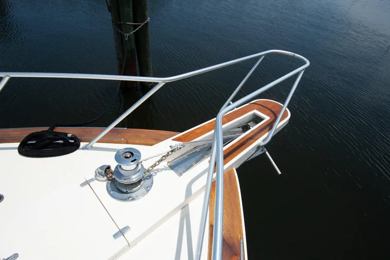 Andiamo Yacht Photos Pics Bow of 1991 Donzi 65 Sportfisher with anchor and railing over water.