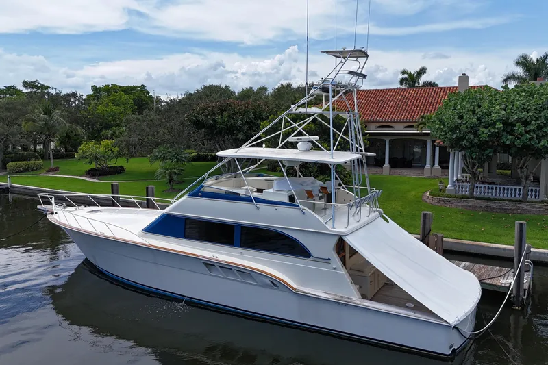 Andiamo Yacht Photos Pics 1991 Donzi 65 Sportfisher yacht docked by a waterfront property.