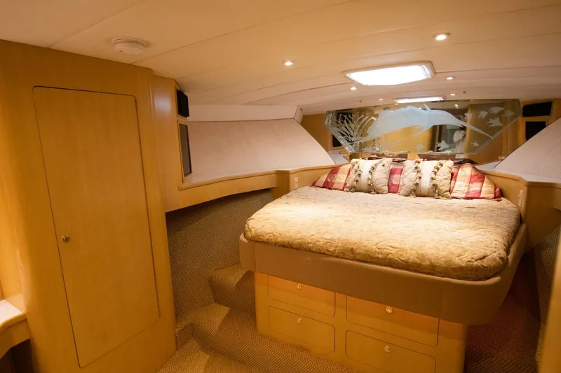 Andiamo Yacht Photos Pics Luxurious cabin interior of 1991 Donzi 65 Sportfisher with cozy bed and elegant decor.