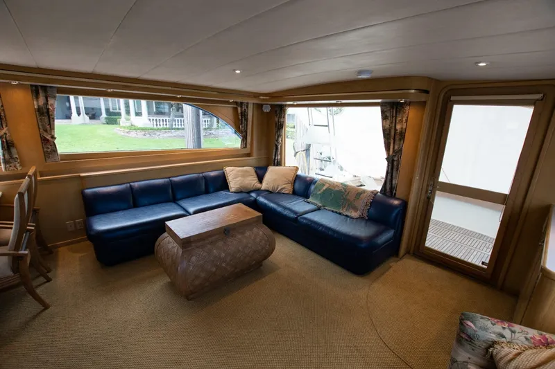 Andiamo Yacht Photos Pics Luxurious interior of 1991 Donzi 65 Sportfisher yacht with blue leather seating and large windows.