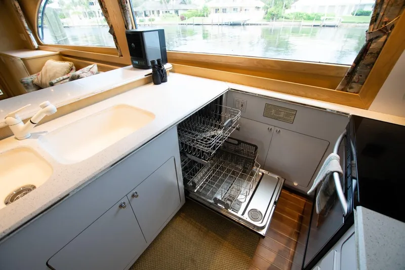 Andiamo Yacht Photos Pics Interior of 1991 Donzi 65 Sportfisher yacht kitchen with open dishwasher.