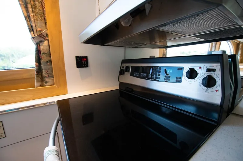 Andiamo Yacht Photos Pics 1991 Donzi 65 Sportfisher kitchen with modern stove and window view.